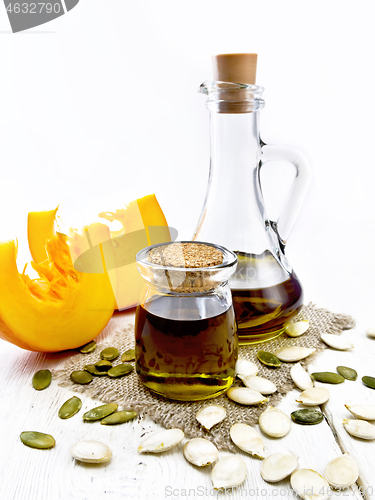 Image of Oil pumpkin in jar and carafe on board