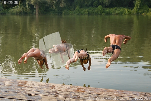 Image of People jumping in the river from a pier