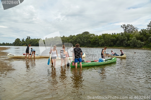 Image of Canoes on the Riverside, People preparing for a trip