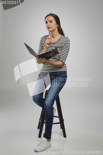 Image of Woman sitting on a bench while think