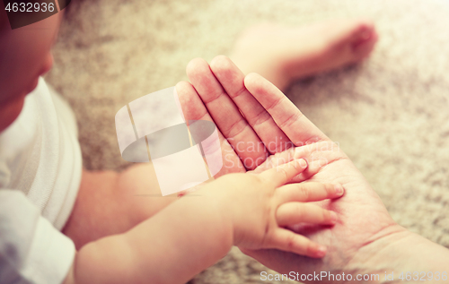 Image of close up of little baby and mother hands