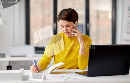 Image of businesswoman calling on smartphone at office