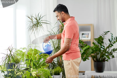 Image of indian man watering houseplants at home