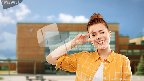 Image of red haired teenage girl showing peace over school