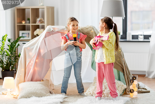 Image of girls with guitar and microphone playing at home