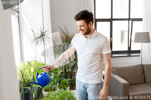 Image of man watering houseplants at home