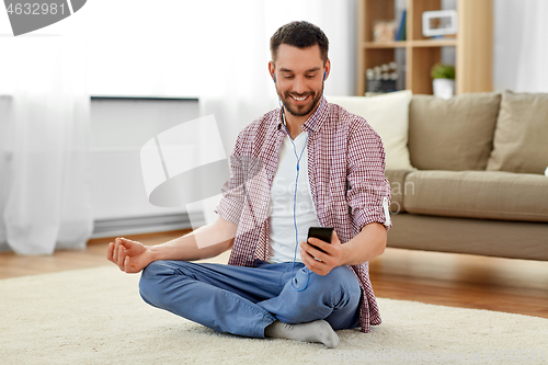 Image of man in earphones listening to music and meditating