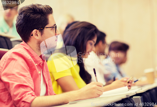 Image of group of students with notebooks in lecture hall