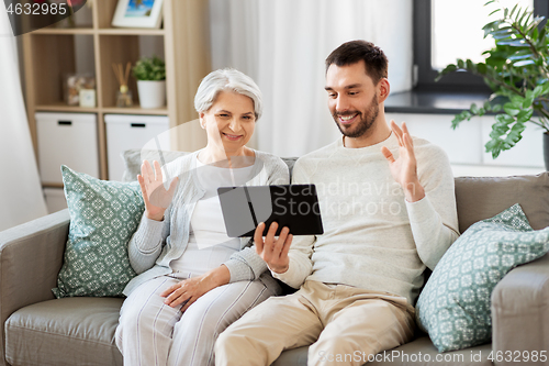 Image of old mother and adult son with tablet pc at home