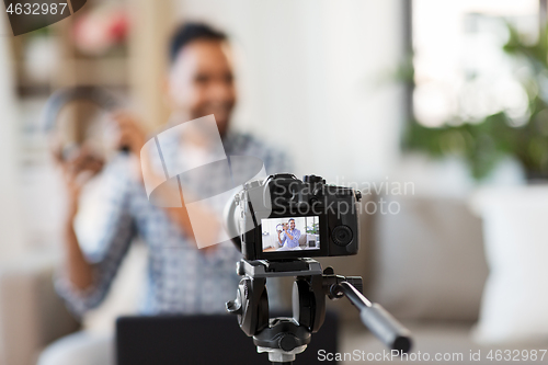 Image of camera recording video blogger with headphones