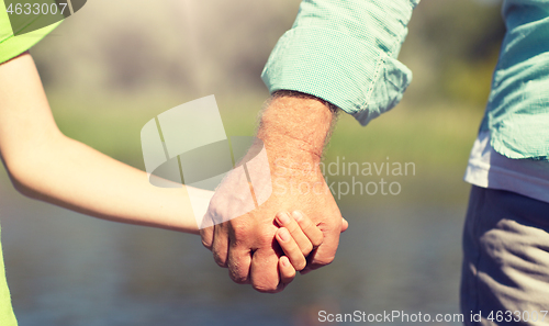 Image of senior man and child holding hands