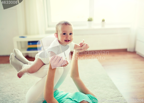 Image of happy mother playing with baby at home