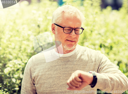 Image of senior man checking time on his wristwatch