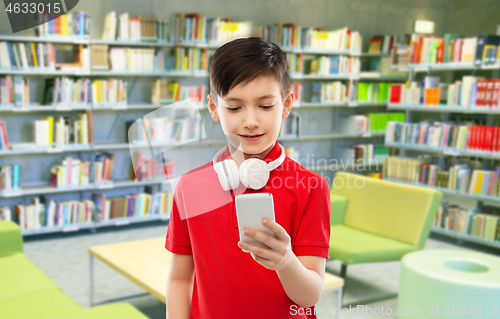 Image of boy with headphones and smartphone at library