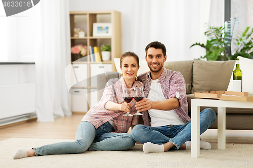 Image of happy couple drinking red wine at home