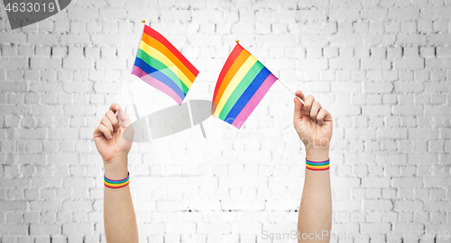 Image of hands with gay pride rainbow flags and wristbands