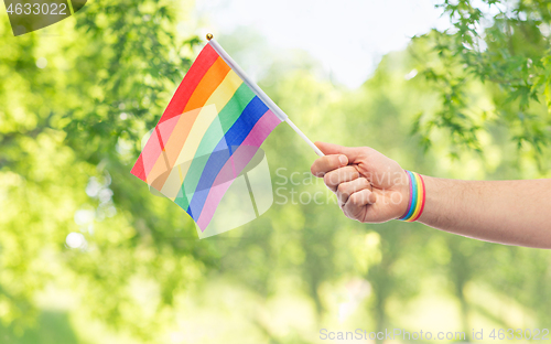 Image of hand with gay pride rainbow flag and wristband