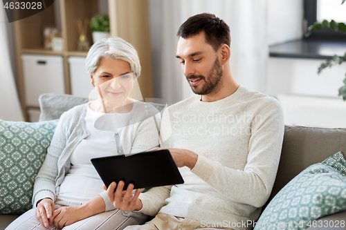 Image of old mother and adult son with tablet pc at home