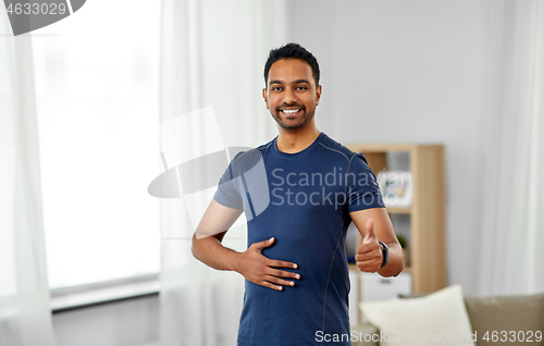 Image of indian man with fitness tracker showing thumbs up