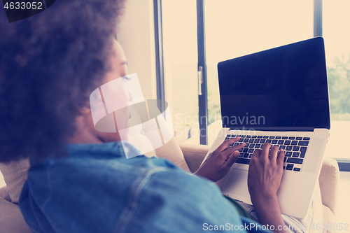 Image of African American women at home in the chair using a laptop