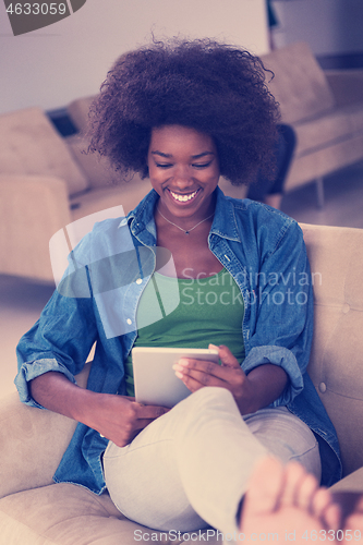 Image of african american woman at home with digital tablet