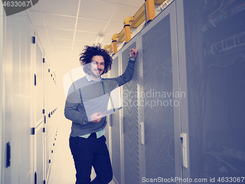 Image of IT engineer working on a tablet computer in server room