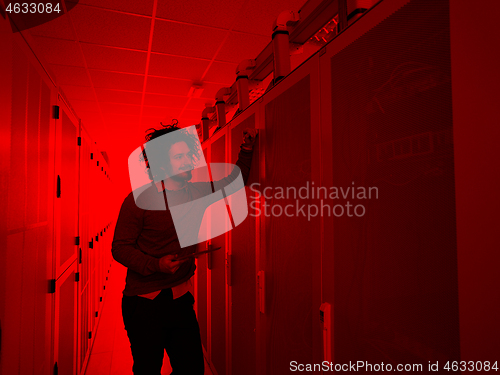 Image of IT engineer working on a tablet computer in server room