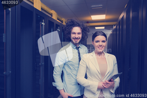 Image of engineer showing working data center server room to female chief