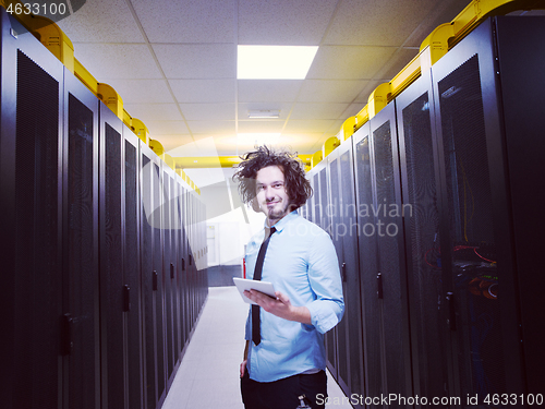 Image of IT engineer working on a tablet computer in server room