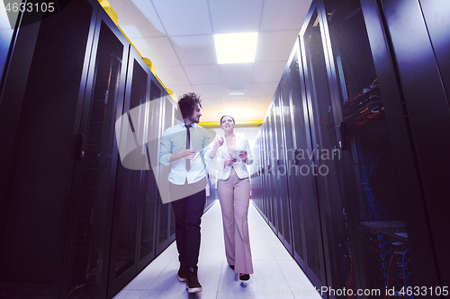 Image of engineer showing working data center server room to female chief