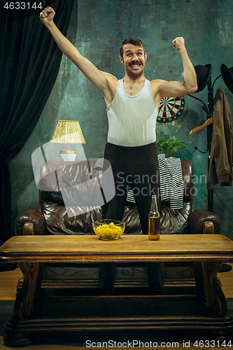 Image of Winner. Overwhelmed cheerful man moving hands while celebrating the victory of a favourite football team