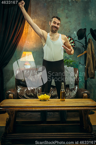 Image of Winner. Overwhelmed cheerful man moving hands while celebrating the victory of a favourite football team