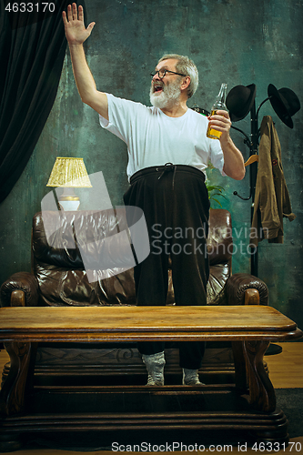Image of Winner. Overwhelmed cheerful man moving hands while celebrating the victory