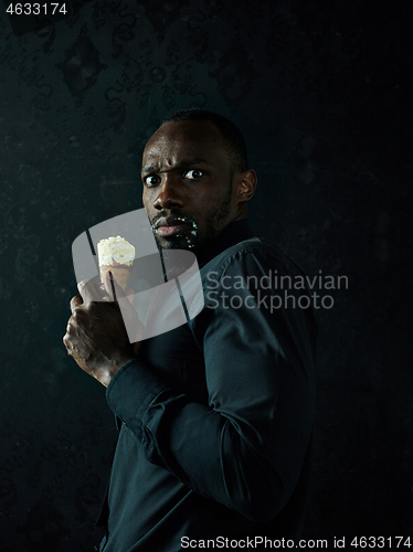 Image of Portrait of afro american man holding ice cream