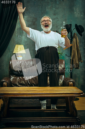 Image of Winner. Overwhelmed cheerful man moving hands while celebrating the victory