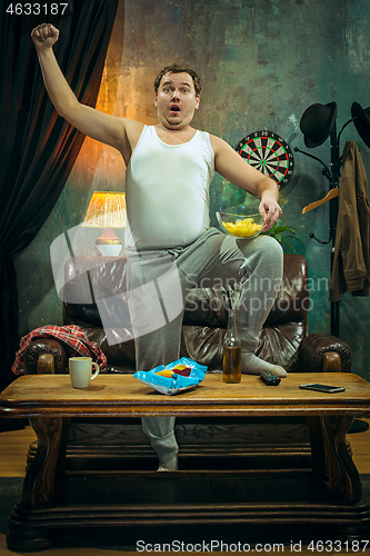 Image of Winner. Overwhelmed cheerful man moving hands while celebrating the victory of a favourite football team