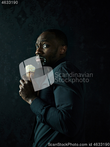 Image of Portrait of afro american man holding ice cream