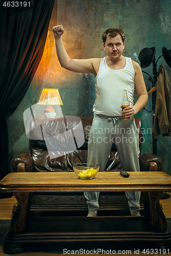 Image of Winner. Overwhelmed cheerful man moving hands while celebrating the victory of a favourite football team