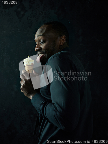 Image of Portrait of afro american man holding ice cream