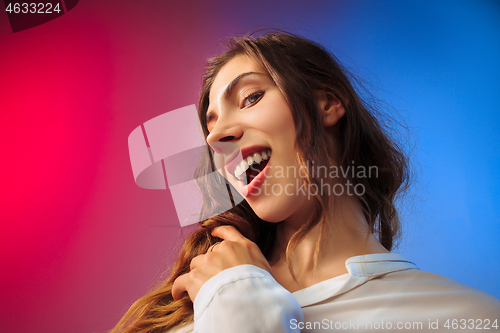 Image of The happy woman standing and smiling against colored background.