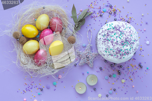 Image of beautiful beautiful Easter composition in purple tones with painted eggs and cake