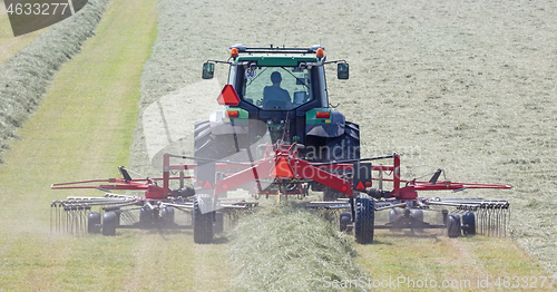 Image of Tractor and grass turner work in dutch meadow