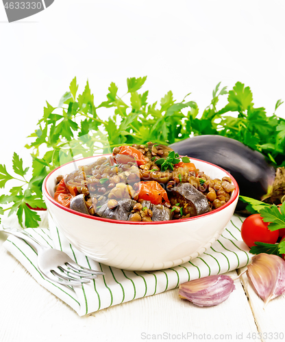 Image of Lentils with eggplant in bowl on wooden board