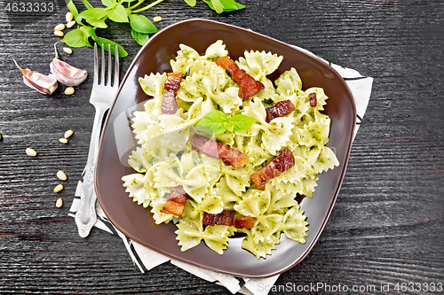 Image of Farfalle with pesto and bacon on dark board top