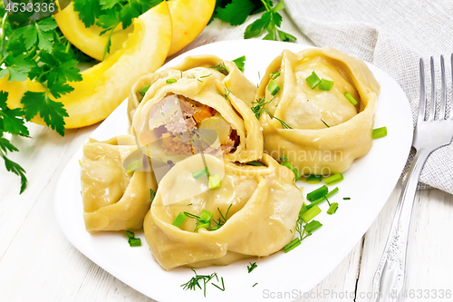 Image of Manty with meat and pumpkin in plate on wooden board