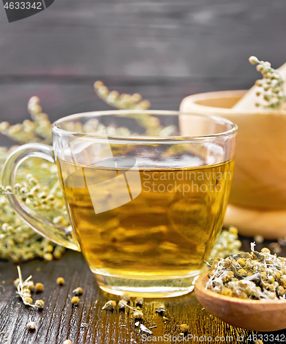 Image of Tea of gray wormwood in glass cup with mortar on board