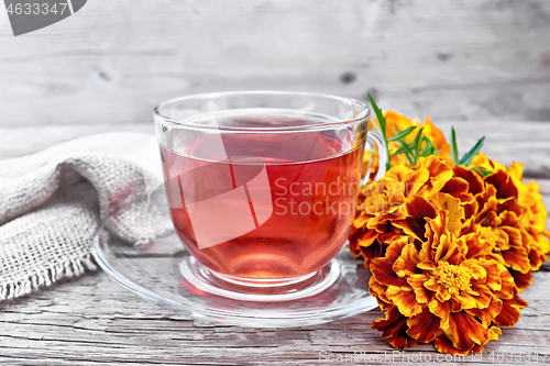 Image of Tea herbal of marigolds in glass cup on wooden board