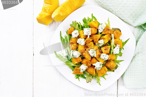 Image of Salad of pumpkin and cheese in plate on board top