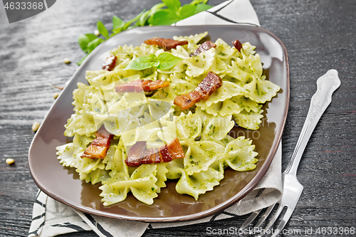 Image of Farfalle with pesto and bacon on dark board