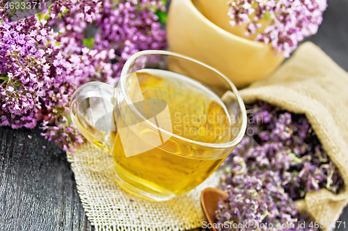 Image of Tea of oregano in cup with mortar on board